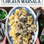 Hands holding a platter of easy chicken marsala recipe with text title box at top