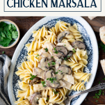 Chicken marsala with pasta on a dinner table with text title box at top
