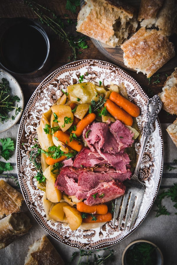 Overhead shot of a platter of baked corned beef and cabbage on a dinner table
