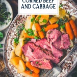 Overhead image of a tray of corned beef and cabbage with potatoes and carrots and text title overlay