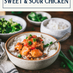 Side shot of sweet and sour chicken in a bowl with a text title box at top
