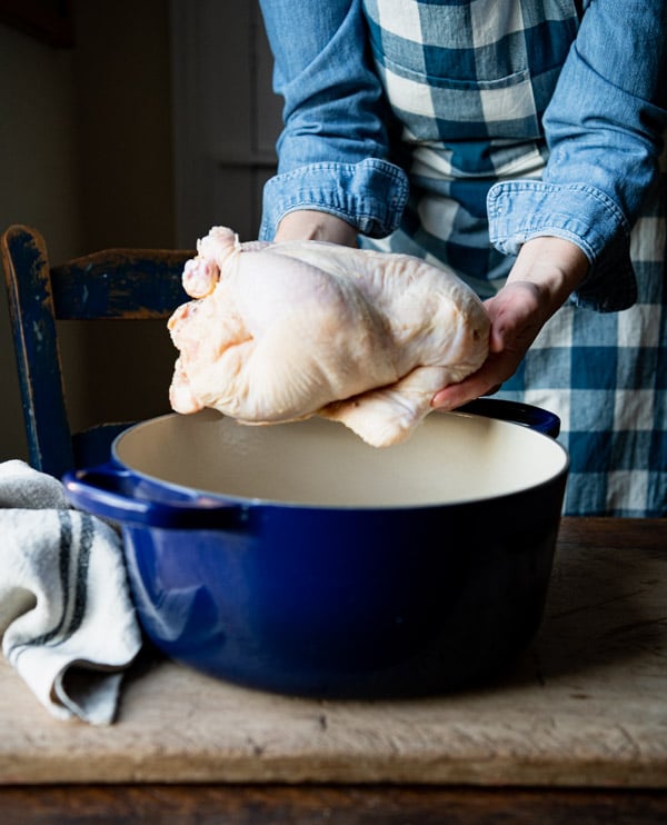 Placing a trussed chicken in a Dutch oven