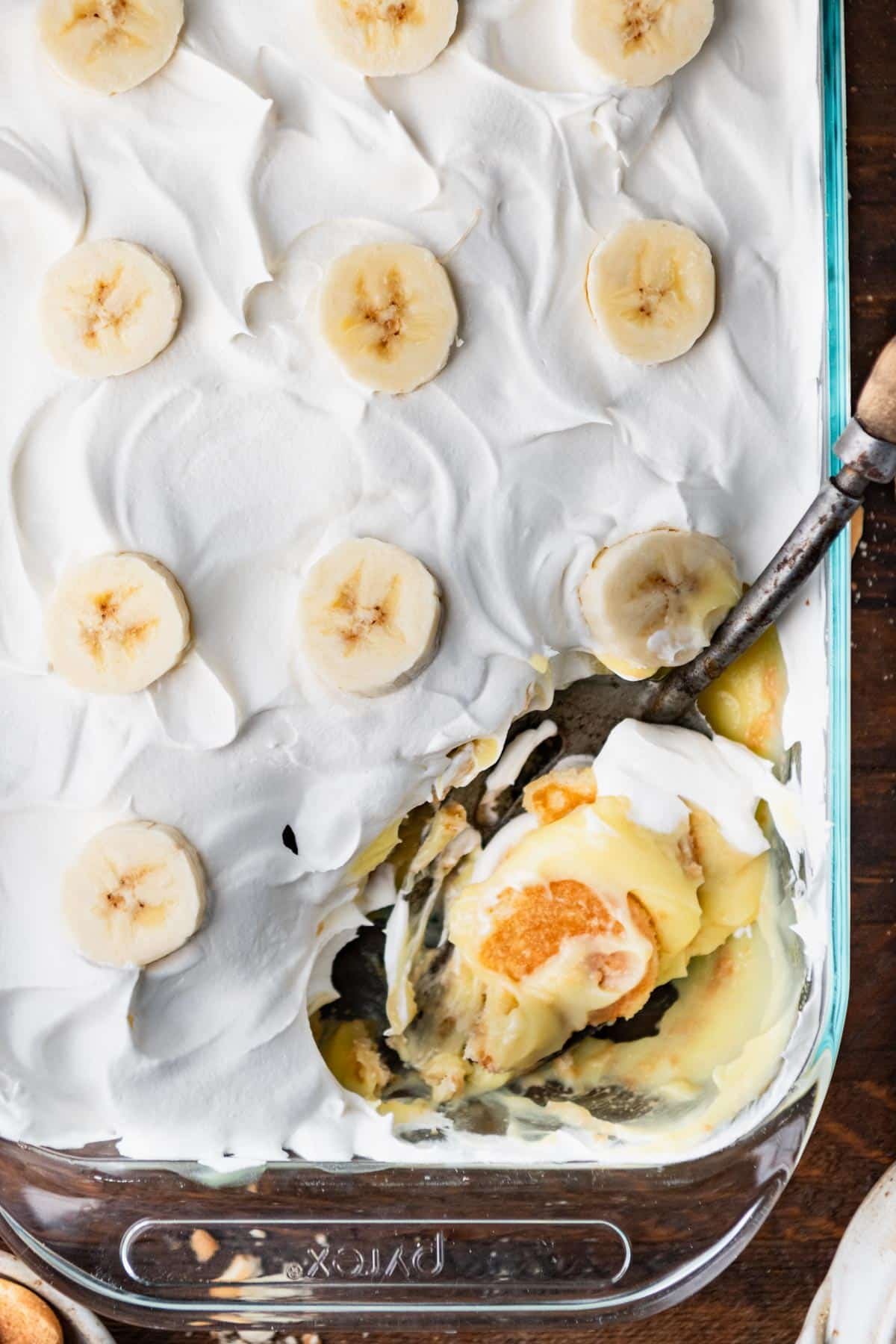 Overhead shot of a serving spoon in a glass dish of semi homemade banana pudding recipe.