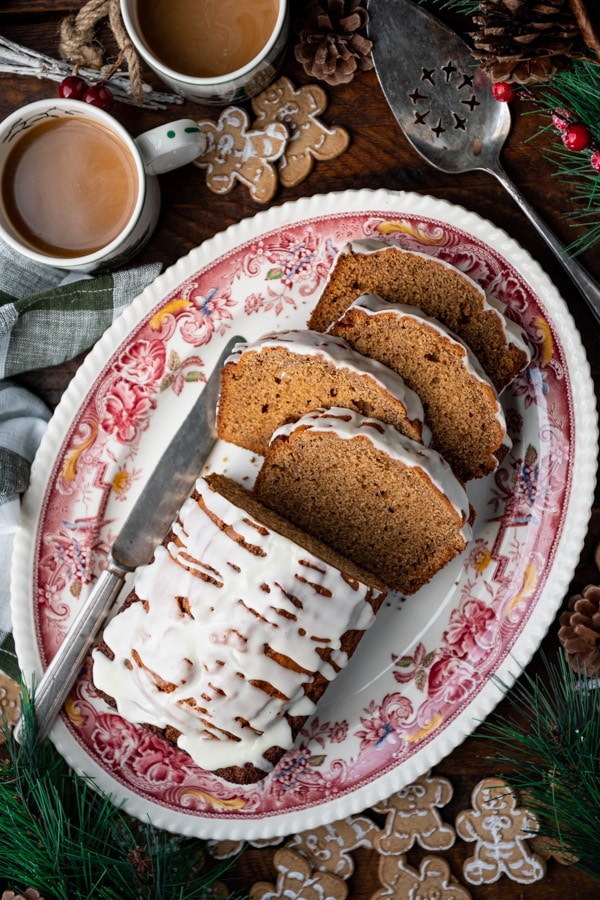 Overhead image of a sliced iced gingerbread loaf cake on a platter