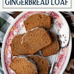Overhead shot of a platter of gingerbread loaf cake slices on a platter with text title box at top