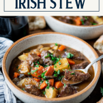 Side shot of a bowl of Irish stew with text title box at top