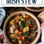 Hands eating a bowl of Guinness Irish stew with text title box at top
