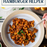Overhead image of hands eating a bowl of homemade hamburger helper with text title box at top.