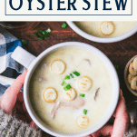 Overhead shot of hands holding a bowl of oyster stew with text title box at top