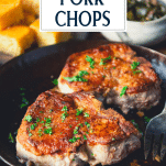 Close up side shot of golden brown fried pork chops in a pan with text title overlay