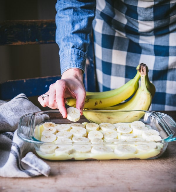 Arranging sliced bananas in a dish.