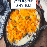 Overhead shot of hands holding a dish of scalloped potatoes with text title overlay