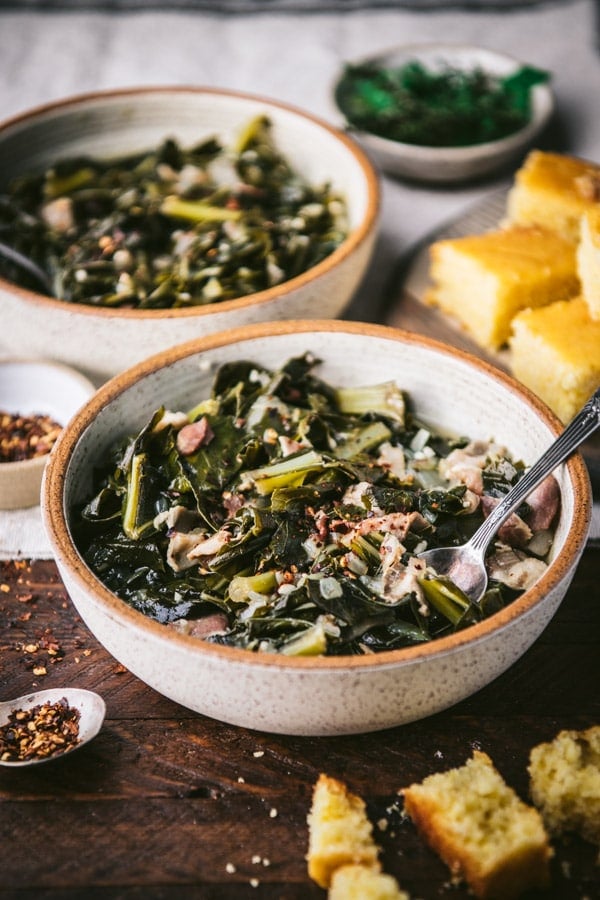 Side shot of southern collard greens in a bowl on a wooden table.