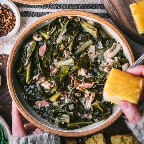 Square overhead shot of a bowl of southern collard greens recipe with a side of cornbread.