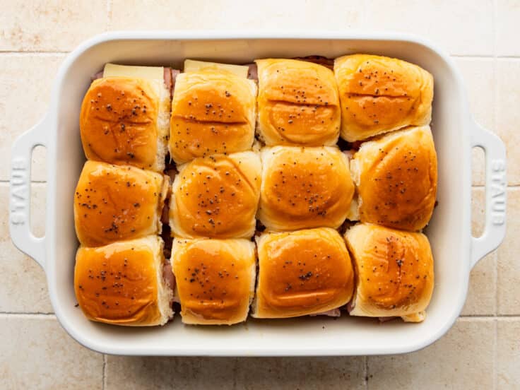 Ham and cheese sliders with butter sauce on top.