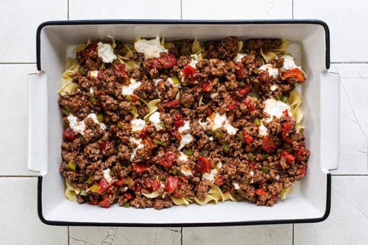 Process shot showing how to assemble the ingredients for a hamburger casserole recipe.