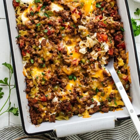Square overhead shot of an Amish hamburger casserole with noodles and sour cream in a white baking dish.