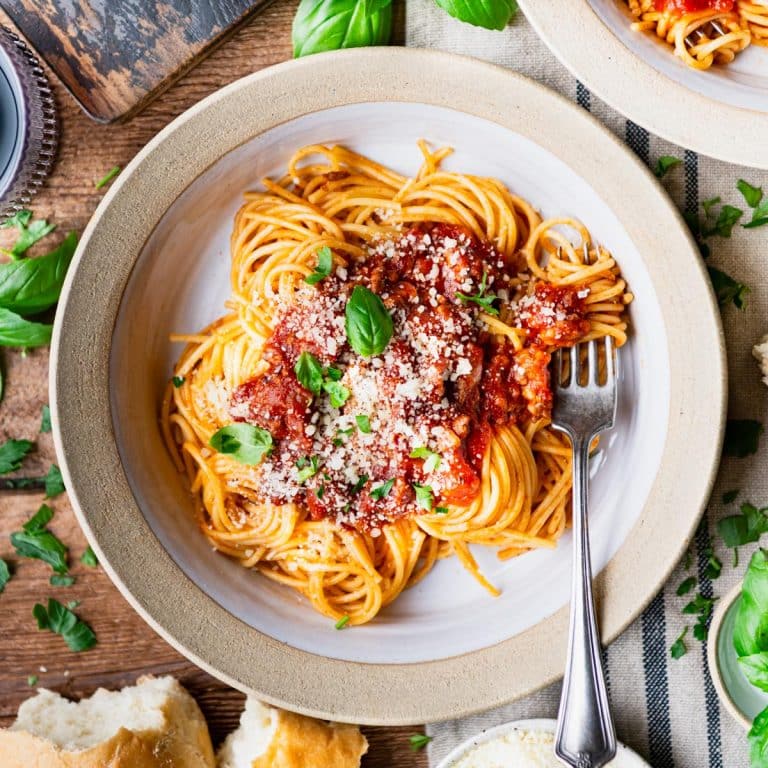 The best homemade spaghetti sauce recipe served over pasta with fresh herbs and Parmesan cheese.