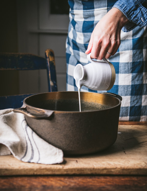 Pouring cream into a pot of soup