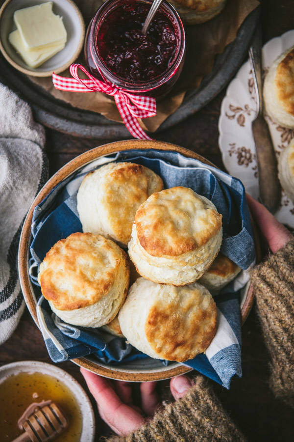 Hands holding a basket of homemade buttermilk biscuits