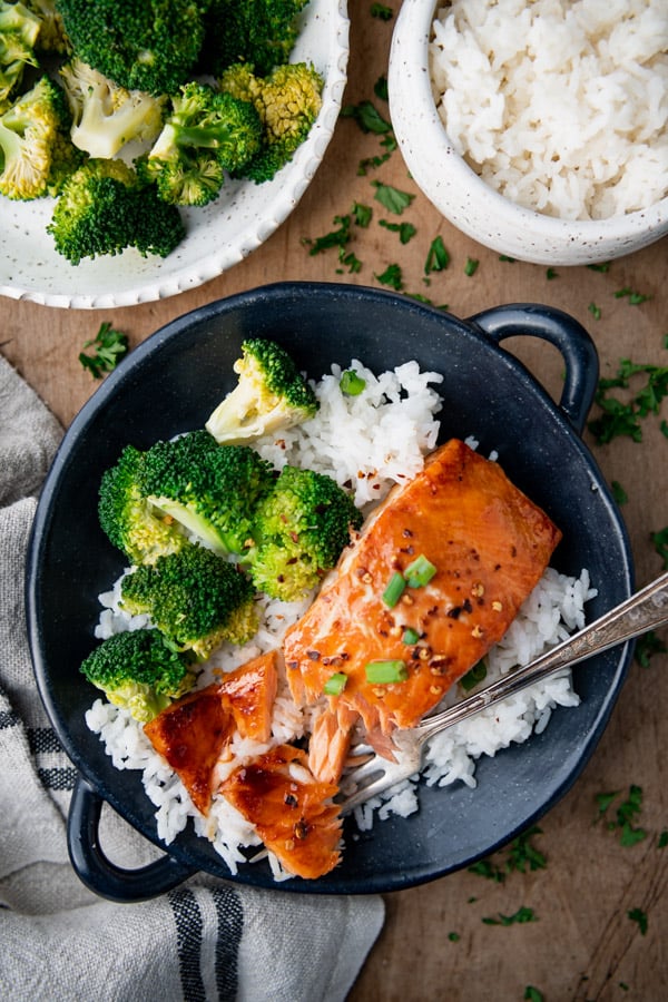 AN overhead image of flakey maple glazed bake salmon, served with steamed broccoli and white rice.