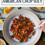 Overhead shot of a fork in a bowl of American chop suey with text title box at top.