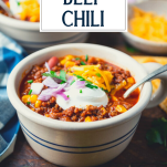 Side shot of the best beef chili recipe in a bowl with text title overlay