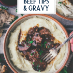 Close overhead image of a bowl of mashed potatoes with beef tips and gravy and text title overlay.