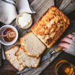 Hands holding a cutting board with a loaf of easy beer bread recipe
