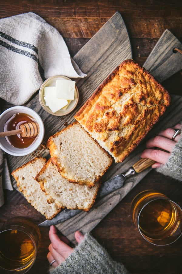 Hands holding a cutting board with a loaf of easy beer bread recipe