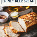 Sliced honey beer bread on a tray with text title box at top
