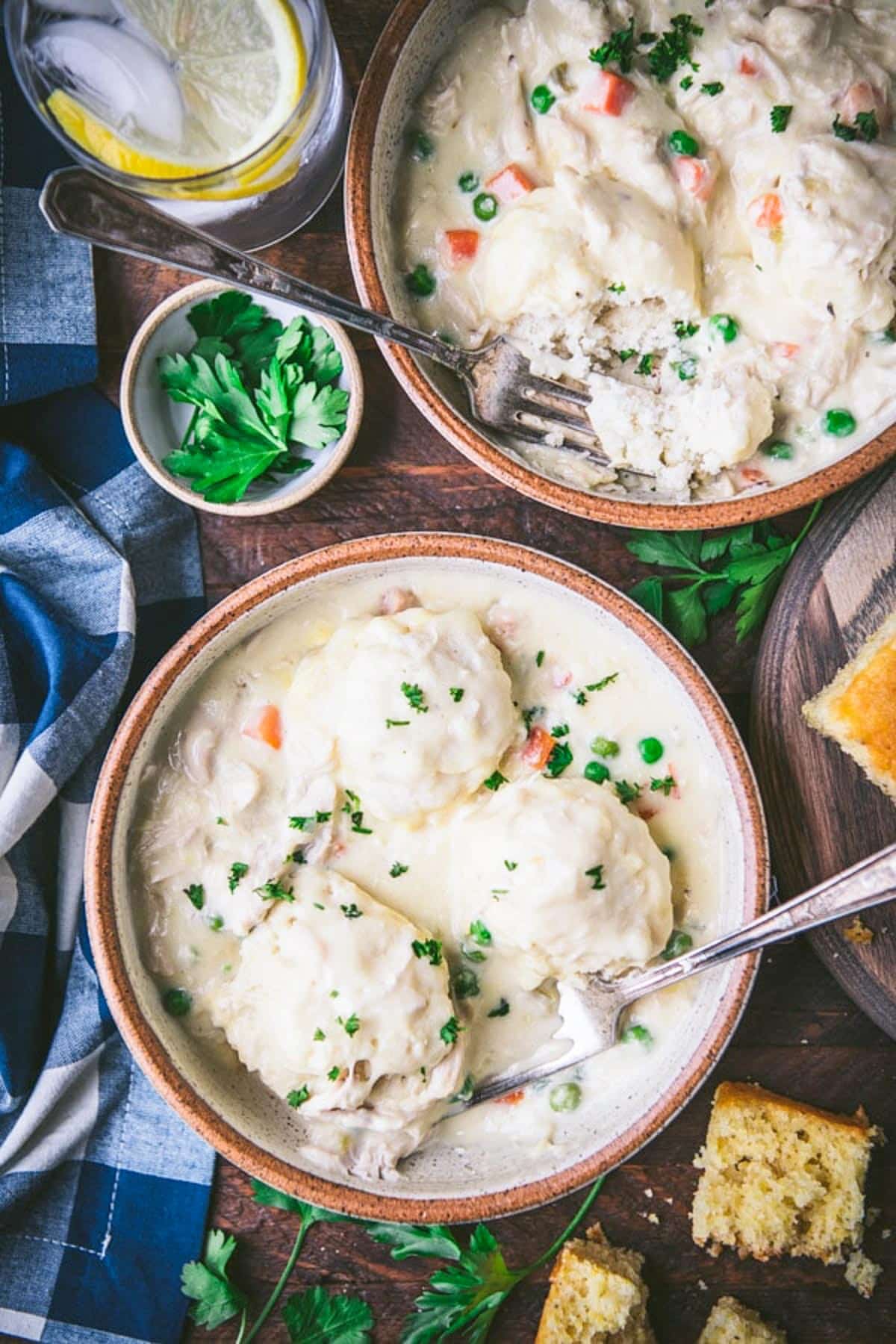 Bowl of bisquick dumplings on a wooden table with a creamy chicken gravy.