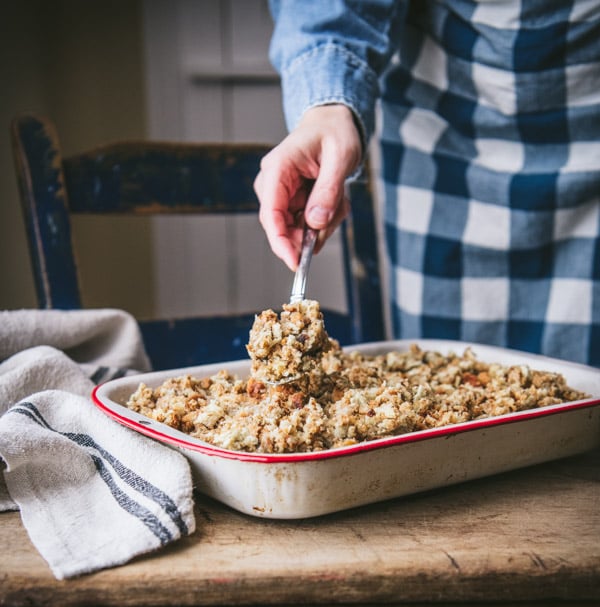 Spreading stuffing on top of a chicken casserole.