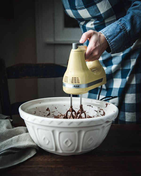 Mixing chocolate cake batter in a white bowl