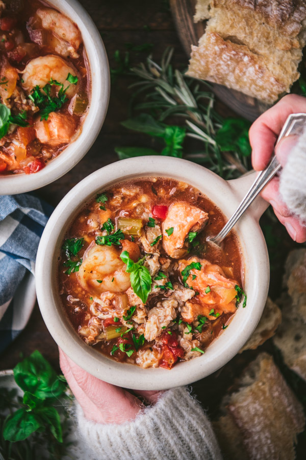 Overhead shot of the best cioppino recipe in a mug with a spoon