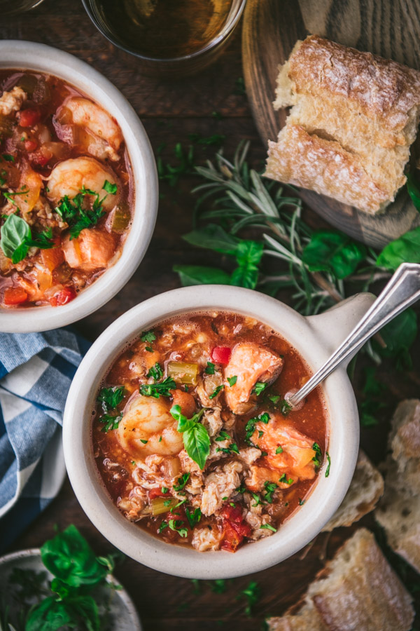 Two bowls of san francisco cioppino on a table with bread