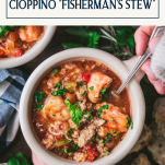 Hands eating a bowl of seafood cioppino soup with text title box at top