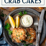 Overhead shot of a plate of Maryland crab cakes with text title box at top