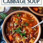 Spoon in a bowl of crockpot cabbage soup with text title box at top