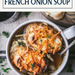 Overhead shot of a bowl of cheesy French onion soup with text title box at top