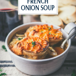 Side shot of the best French onion soup recipe in a white bowl with text title overlay