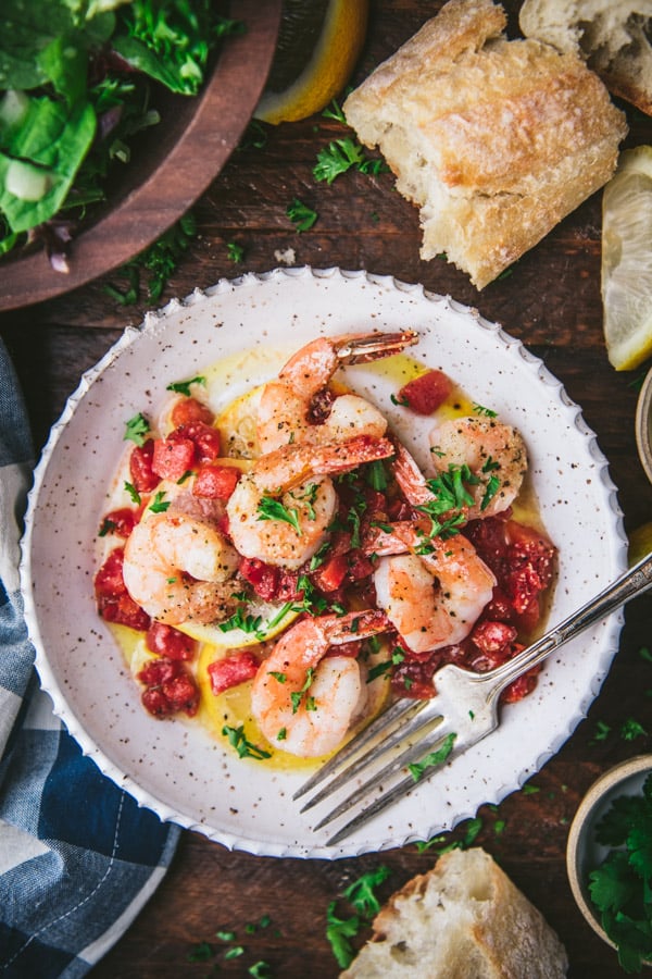 Overhead shot of a plate of the best baked shrimp recipe served with a side salad and bread.