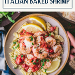 Overhead shot of hands holding a bowl of Italian baked shrimp with text title box at top