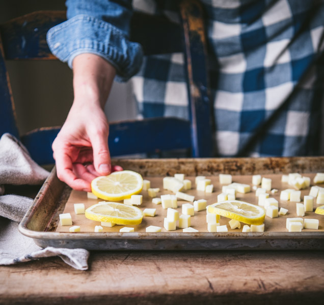 Arranging lemons and butter on a sheet pan.