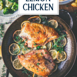 Overhead shot of a pan of lemon chicken breast on a dinner table with text title overlay
