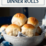 Side shot of a bowl of homemade dinner rolls with text title box at top