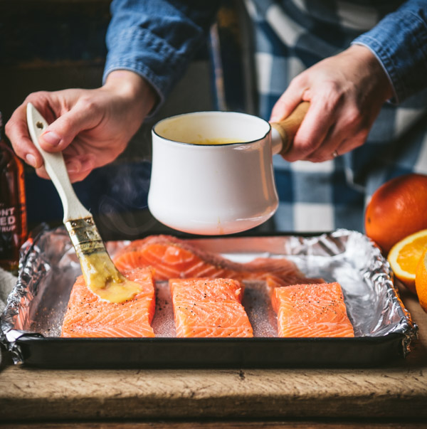Pintar los filetes de salmón con glaseado de naranja antes de hornear.