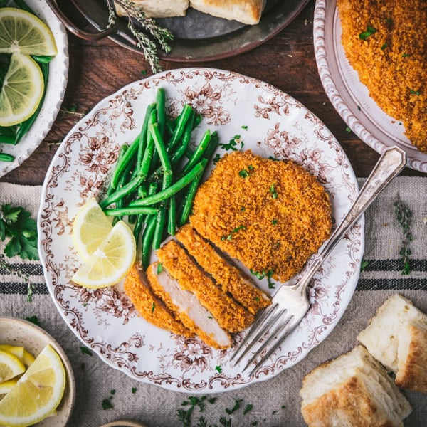 Overhead shot of oven baked fried chicken breast on a plate with green beans