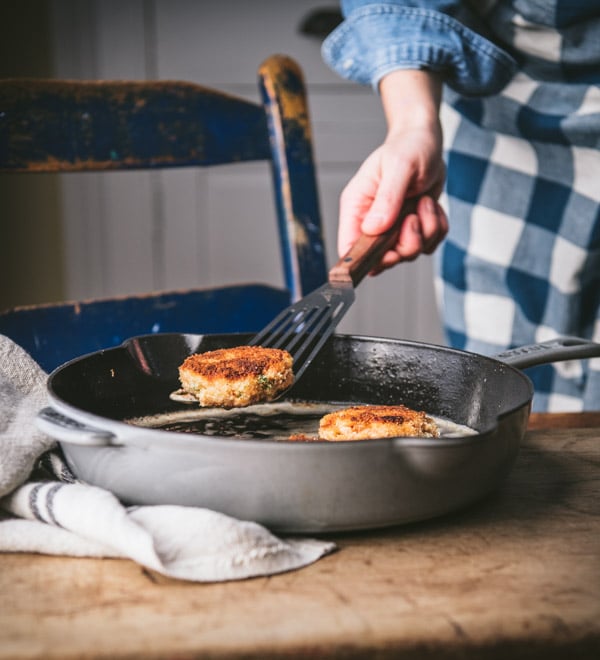 Pan frying salmon croquettes in a cast iron skillet