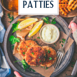 Hands holding a plate of salmon patties with text title overlay